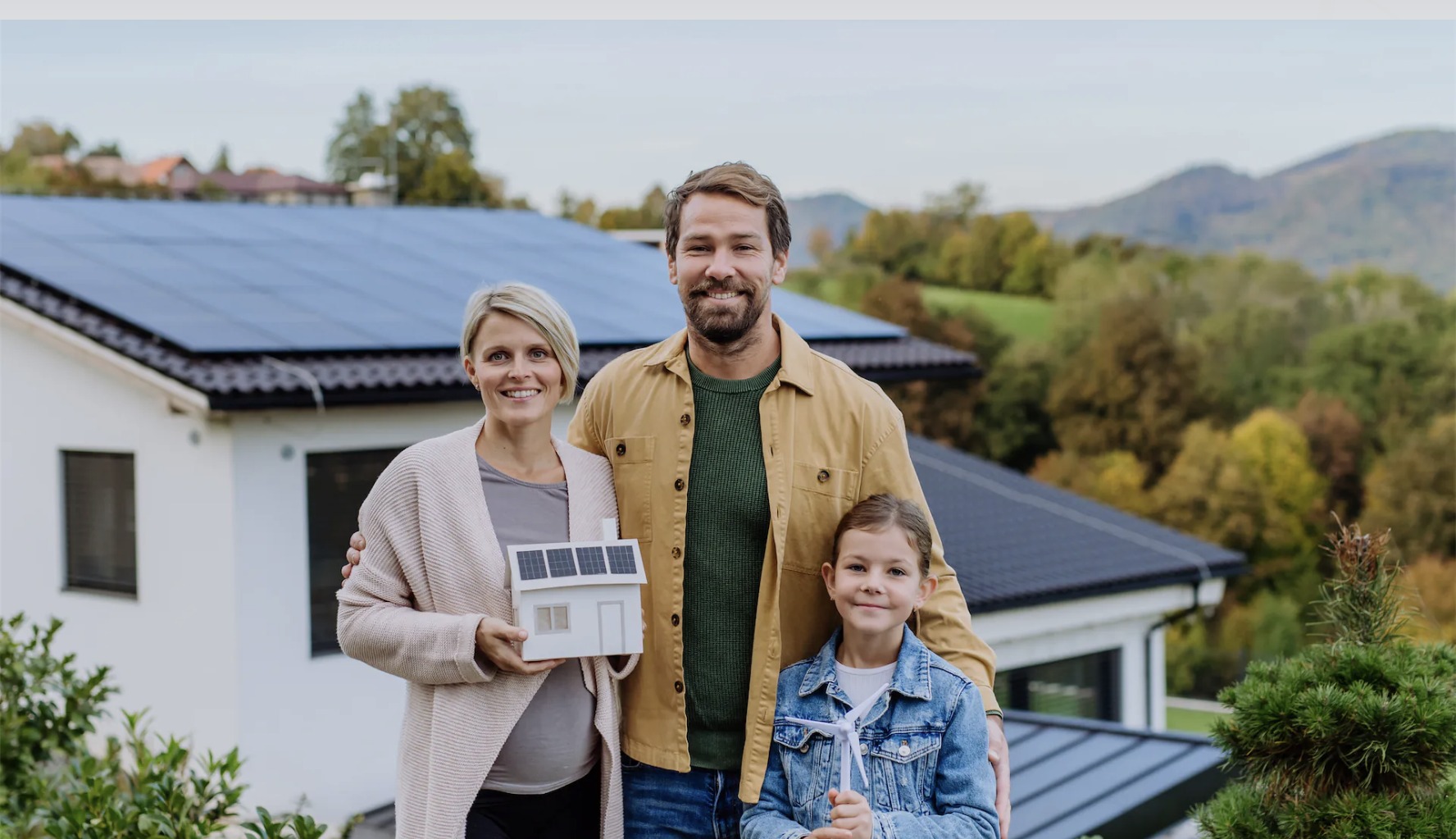 Familie vor einem modernen Haus mit Photovoltaikanlage